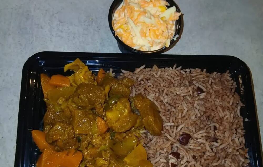 Curry goat with rice and peas and coleslaw